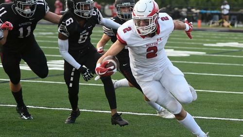 Milton WR Dylan Leonard (2) runs against the defense of Jackson Michaels (11) and Jared Rumph (6) during high school football featuring Milton at Alpharetta on Friday, Aug. 24, 2018.