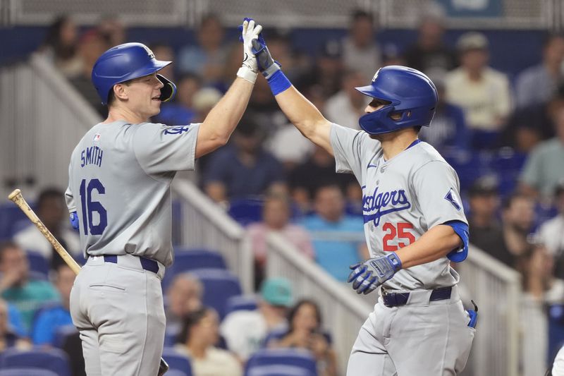 Los Angeles Dodgers' Tommy Edman (25) celebrates his two-run home run with Will Smith (16) during the fourth inning of a baseball game against the Miami Marlins, Wednesday, Sept. 18, 2024, in Miami. (AP Photo/Marta Lavandier)