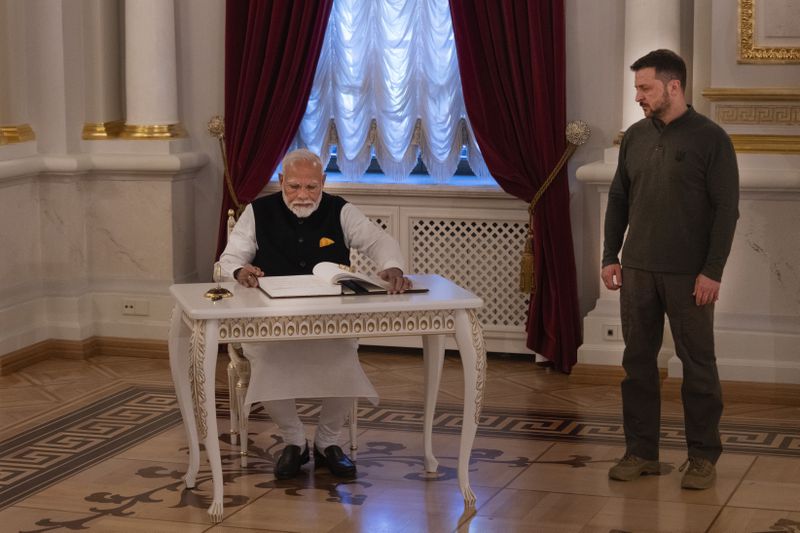 Indian Prime Minister Narendra Modi, signs the guest book as Ukraine's President Volodymyr Zelenskyy looks on in Kyiv, Ukraine, Friday, Aug. 23, 2024. (AP Photo/Efrem Lukatsky)