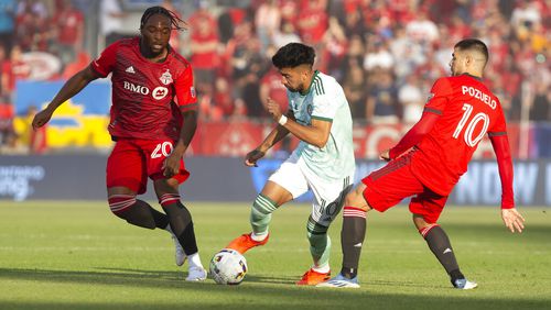 Atlanta United midfielder Marcelino Moreno, center, takes the ball between Toronto FC forward Ayo Akinola and midfielder Alejandro Pozuelo, right, during the first half of an MLS soccer match Saturday, June 25, 2022, in Toronto. (Chris Young/The Canadian Press via AP)