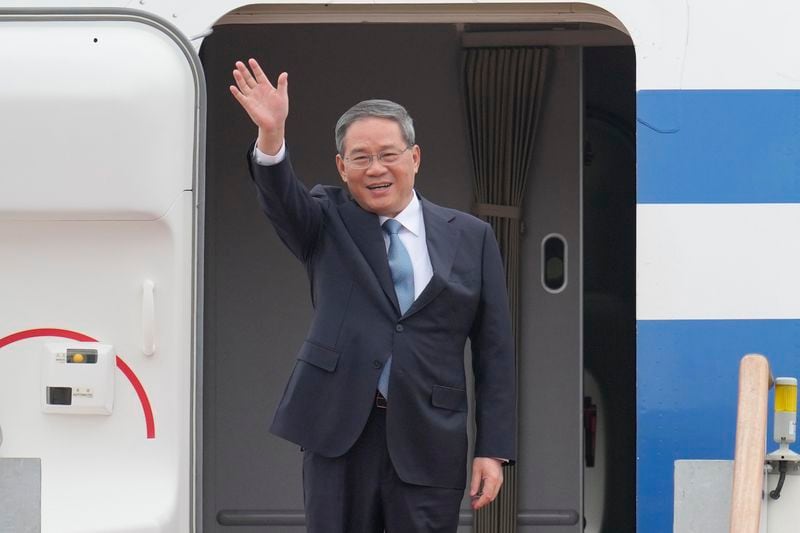 Chinese Premier Li Qiang waves to media members upon his arrival for trilateral meetings at the Seoul airport in Seongnam, South Korea, Sunday, May 26, 2024. Leaders of South Korea, China and Japan will meet next week in Seoul for their first trilateral talks since 2019. (AP Photo/Lee Jin-man)