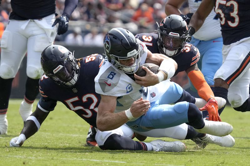 Tennessee Titans quarterback Will Levis carries the ball and is tackled by Chicago Bears linebacker T.J. Edwards (53) and safety Kevin Byard III (31) during the first half of an NFL football game Sunday, Sept. 8, 2024, in Chicago. (AP Photo/Nam Y. Huh)