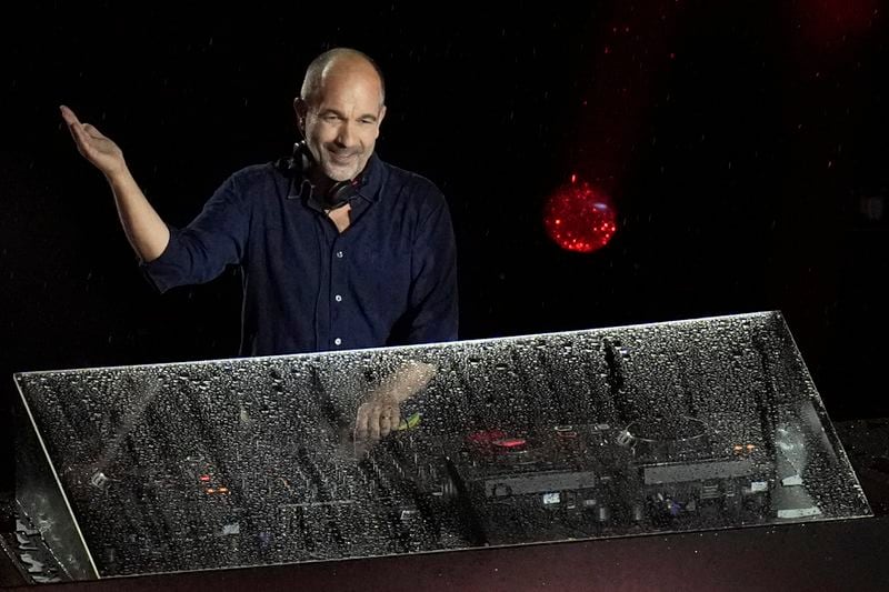 DJ Etienne de Crecy performs during the closing ceremony of the 2024 Paralympics under the rain, Sunday, Sept. 8, 2024, in Paris, France. (AP Photo/Christophe Ena)