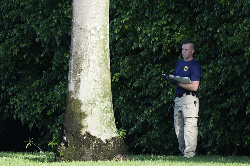 An FBI officer works outside of Trump International Golf Club after the apparent assassination attempt of Republican presidential nominee and former President Donald Trump Monday, Sept. 16, 2024, in West Palm Beach, Fla. (AP Photo/Lynne Sladky)