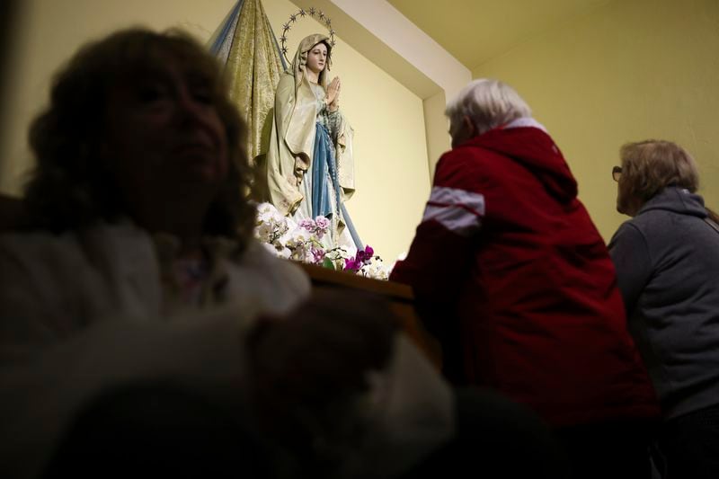 Pilgrims recite their prayers next to the statue of the Virgin Mary inside the St. James Church in Medjugorje, Bosnia, Thursday, Sept. 19, 2024. (AP Photo/Armin Durgut)