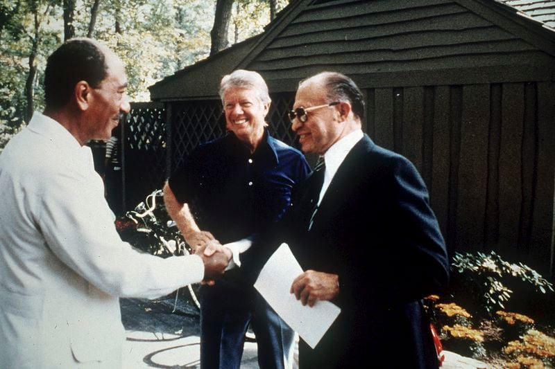 FILE - Egypt's President Anwar Sadat, left, shakes hands with Israeli Prime Minister Menachem Begin as U.S. President Jimmy Carter, center, looks on at Camp David, Md., Sept. 7, 1978. (AP Photo, File)