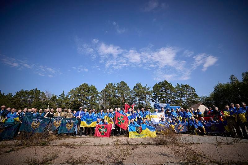 Ukrainians pose for a photo after being released in a prisoner exchange at an undisclosed location in Ukraine, Saturday Sept. 14, 2024. (Ukrainian Presidential Press Office via AP)