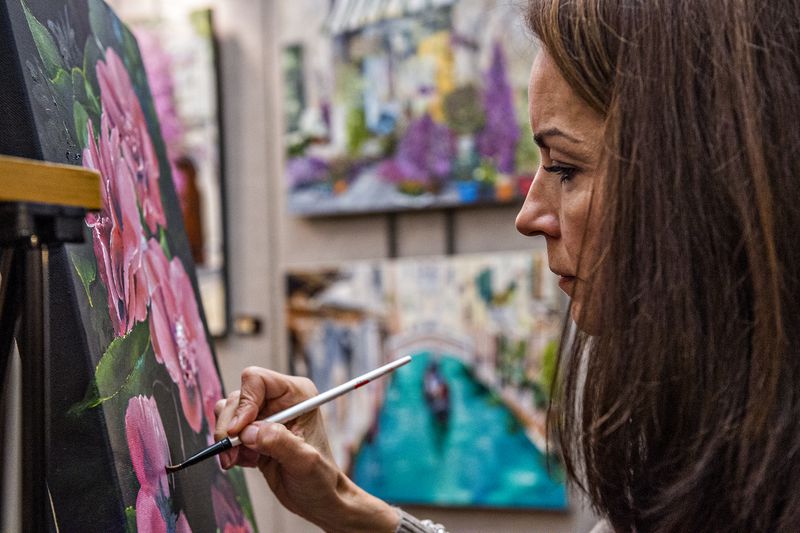 Julie Rogers paints as she waits for people to drop by her booth during the Callanwolde Arts Festival in Atlanta on Saturday, January 23, 2016. The festival featured numerous local and regional artists with their booths set up throughout the fine arts center. JONATHAN PHILLIPS / SPECIAL