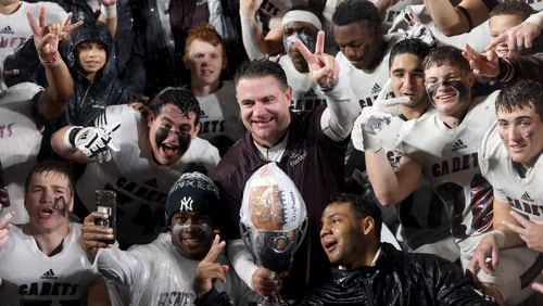 Benedictine Cadets head coach Danny Britt celebrates with players after their 14-13 win against the Cedartown Bulldogs in the GHSA Class 4A finalst  aCenter Parc Stadium, Friday, December 9, 2022, in Atlanta.  (Jason Getz / Jason.Getz@ajc.com)