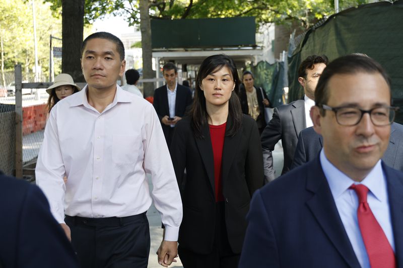 Attorney Seth DuCharme walks in front of former New York Governor Kathy Hochul aide Linda Sun, center, and her husband, Christopher Hu, left, leave Brooklyn Federal Court after their arraignment, Tuesday, Sept. 3, 2024, in New York. Sun is charged with being an aide to the Chinese government. (AP Photo/Corey Sipkin)