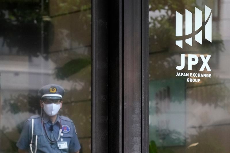FILE - A security guard stands guard at the entrance of Tokyo Stock Exchange building in Tokyo, on May 28, 2024. Asian shares traded mixed Wednesday, June 5, 2024, as investors weighed recent data highlighting a slowing U.S. economy that offers both upsides and downsides for Wall Street. (AP Photo/Eugene Hoshiko)