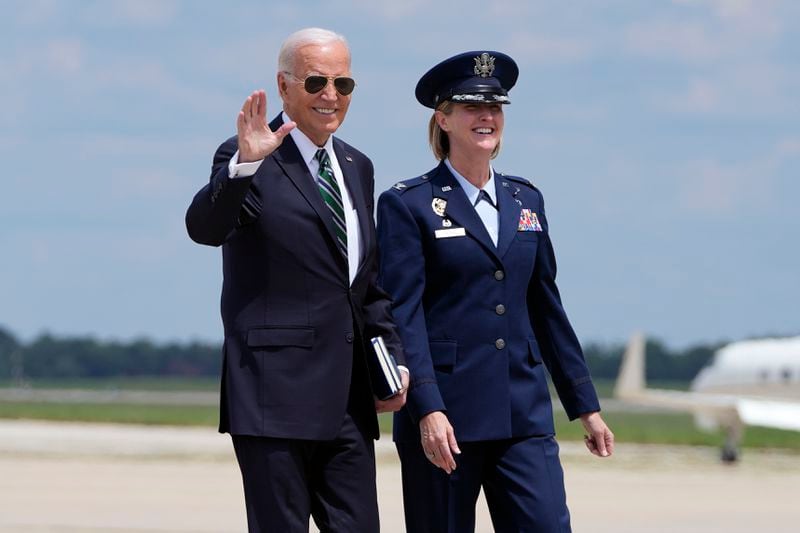 President Joe Biden, escorted by Air Force Col. Angela Ochoa, Commander, 89th Airlift Wing, walks to Air Force One as he arrives to depart, Tuesday, Aug. 13, 2024, at Joint Base Andrews, Md., en route to New Orleans. (AP Photo/Mark Schiefelbein)