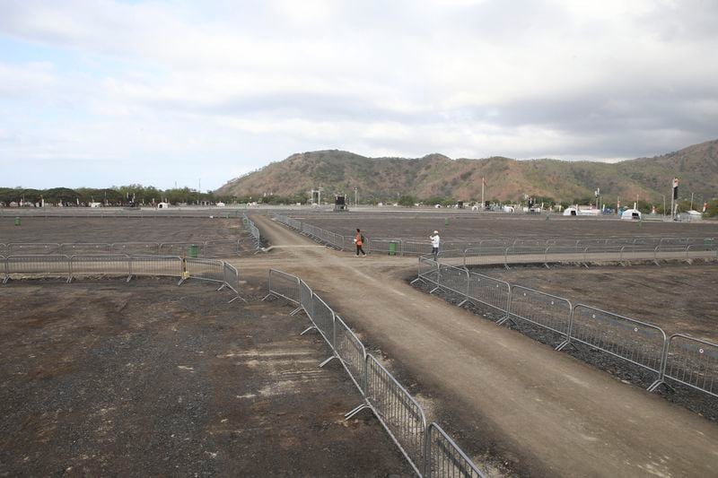 People walk past Tasitolu, an open field on the coast which will be the venue of a papal Mass, in Dili, East Timor, Thursday, Sept. 5, 2024. (AP Photo/Firdia Lisnawati)