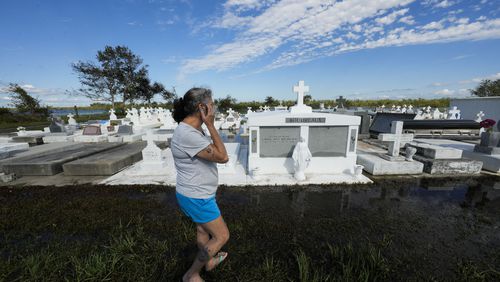 Lori-Ann Bergeron checks on the graves of her sister and mother to see that they were not disturbed by flooding, in the aftermath of Hurricane Francine, in Dulac, La., Thursday, Sept. 12, 2024. (AP Photo/Gerald Herbert)