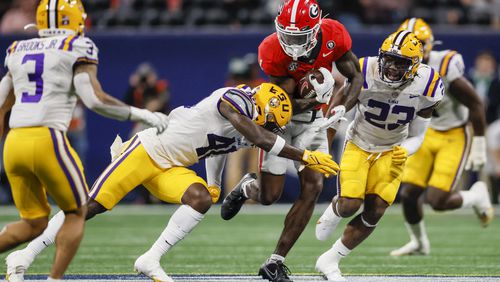 Georgia wide receiver Marcus Rosemy-Jacksaint (1) runs after a catch against LSU Tigers linebackers Harold Perkins Jr. (40, center) and Micah Baskerville (23) during the second half in the SEC Championship at Mercedes-Benz Stadium, Saturday, December 3, 2022, in Atlanta. Georgia won 50-30. Jason Getz / Jason.Getz@ajc.com)
