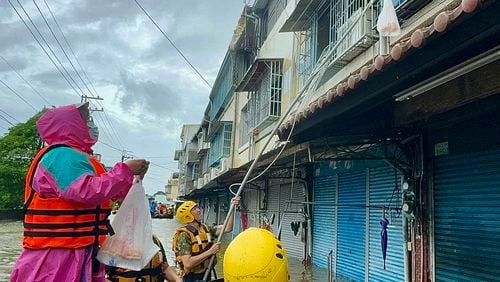 In this photo released by the Taiwan Ministry of National Defense, rescue workers distribute supplies to residents trapped by flood waters in the aftermath of Typhoon Gaemi in Chiayi county in southwestern Taiwan, Friday, July 26, 2024. (Taiwan Ministry of National Defense via AP)