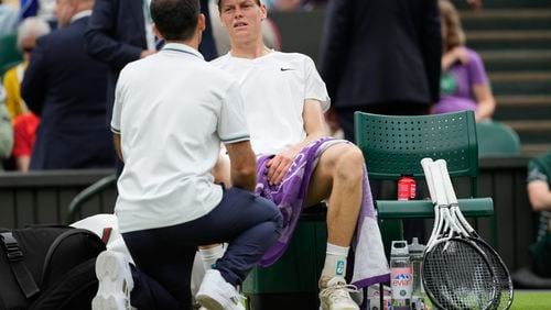 Jannik Sinner of Italy reacts as he receives treatment from a trainer during his quarterfinal match against Daniil Medvedev of Russia at the Wimbledon tennis championships in London, Tuesday, July 9, 2024. (AP Photo/Alberto Pezzali)