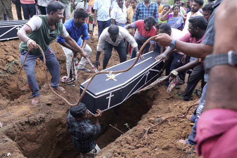Men lower a coffin into a grave pit to bury a man, who died after drinking illegally brewed liquor, in Kallakurichi district of the southern Indian state of Tamil Nadu, India, Thursday, June 20, 2024. The state's chief minister M K Stalin said the 34 died after consuming liquor that was tainted with methanol, according to the Press Trust of India news agency. (AP Photo/R. Parthibhan)