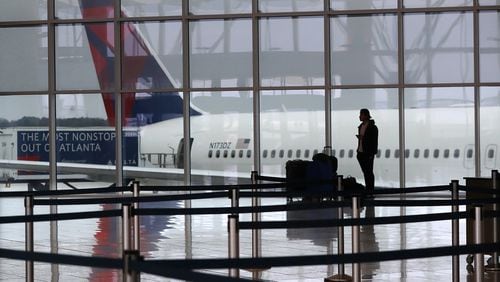 March 16, 2020 Atlanta: A Delta plane sits at the International Terminal at Hartsfield Jackson International Airport with a solitary international traveler trying to get a flight home amid new European travel restrictions on Monday, March 16, 2020, in Atlanta. International and domestic air travel has been hammered by the coronavirus.   Curtis Compton ccompton@ajc.com