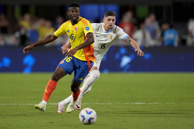 Colombia's Jefferson Lerma (16) and Uruguay's Federico Valverde battle for the ball during a Copa America semifinal soccer match in Charlotte, N.C., Wednesday, July 10, 2024. (AP Photo/Julia Nikhinson)