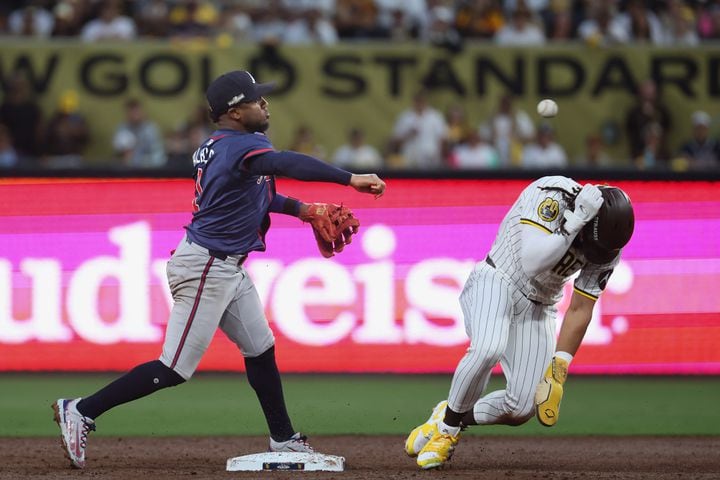 Atlanta Braves second base Ozzie Albies (1) throws past San Diego Padres’ baserunner Fernando Tatis Jr. (23) for a double play on a grounder bySan Diego Padres’ Manny Machado during the third inning of National League Division Series Wild Card Game One at Petco Park in San Diego on Tuesday, Oct. 1, 2024.   (Jason Getz / Jason.Getz@ajc.com)