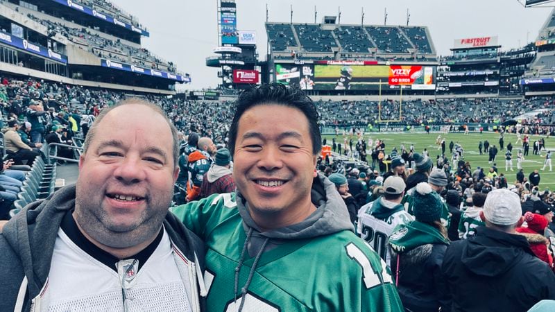 Walt TK and Michael Lo pose at a Philadelphia Eagles game.