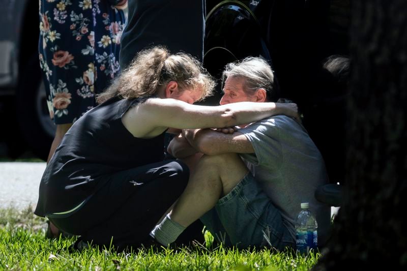 Family of a deceased suspected shooter react near the scene where authorities say a sheriff’s deputy was shot and wounded and is in “very critical” condition at a hospital, in Carrollton, Ga., Tuesday, Aug. 20, 2024. (John Spink/Atlanta Journal-Constitution via AP)