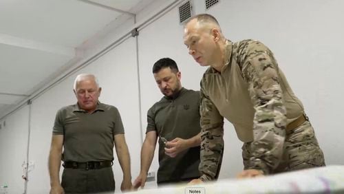 In this photo provided by the Ukrainian Presidential Press Office, Ukrainian President Volodymyr Zelenskyy, center, Commander-in-Chief Oleksandr Syrsky, right, look at a map during their visit to Sumy, Ukraine, Thursday, Aug. 22, 2024. (Ukrainian Presidential Press Office via AP)