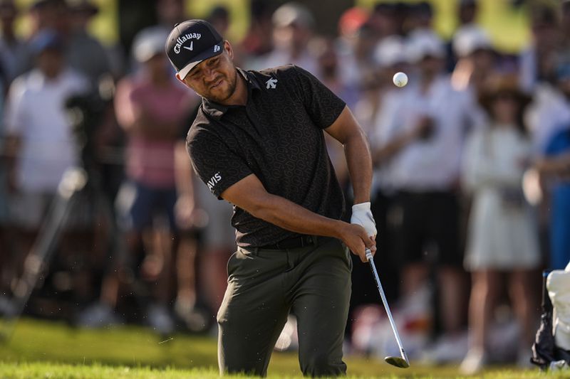 Xander Schauffele chips to the 18th green during the first round of the Tour Championship golf tournament, Thursday, Aug. 29, 2024, in Atlanta. (AP Photo/Mike Stewart)