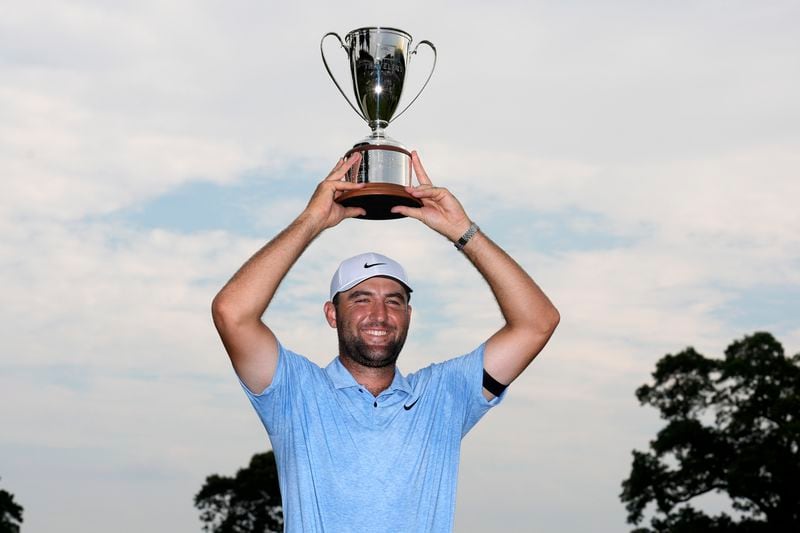 Scottie Scheffler holds up his trophy after winning the Travelers Championship golf tournament at TPC River Highlands, Sunday, June 23, 2024, in Cromwell, Conn. (AP Photo/Seth Wenig)