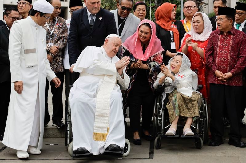 Pope Francis, center, and the Grand Imam of Istiqlal Mosque Nasaruddin Umar, left, pose for a family photo following an interreligious meeting with religious leaders at the Istiqlal Mosque in Jakarta, Thursday, Sept. 5, 2024. (Yasuyoshi Chiba/Pool Photo via AP)