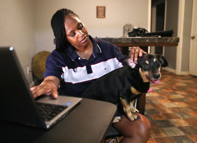 Griffin works from her apartment with her dog Prince. After first closing due to the pandemic, the daycare Monica Griffin works at has shifted to some offer teleworking. (Curtis Compton / ccompton@ajc.com)