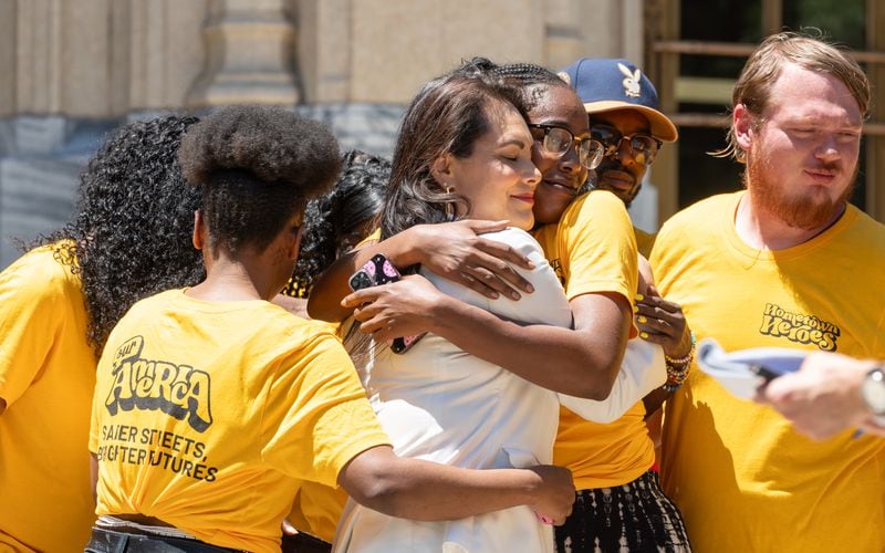 State House candidate Elvia Davila (at left) hugs a supporter of Our America, which held a rally in favor of the Atlanta Public Safety Training Center on the steps of City Hall on Monday, May 20, 2024. (Ben Hendren for the Atlanta Journal Constitution)