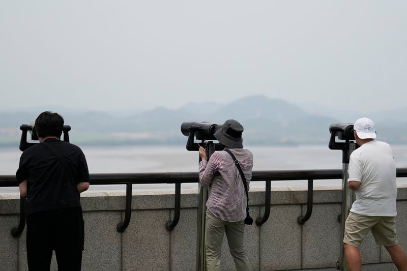 Visitors uses binoculars to see the North Korean side from the unification observatory in Paju, South Korea, Friday, June 21, 2024. South Korea summoned the Russian ambassador to protest the country's new defense pact with North Korea on Friday, as border tensions continued to rise with vague threats and brief, seemingly accidental incursions by North Korean troops. (AP Photo/Lee Jin-man)