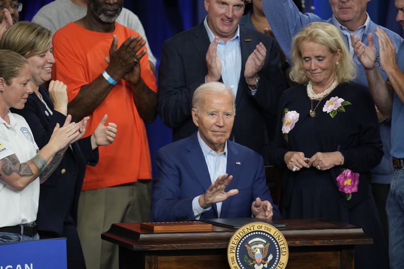 President Joe Biden signs an executive order for federal grants that would prioritize projects with labor agreements, wage standards and benefits such as access to child care and apprenticeship programs, during a visit to the U.A. Local 190 Training Center in Ann Arbor, Mich., Friday, Sept. 6, 2024. (AP Photo/Paul Sancya)