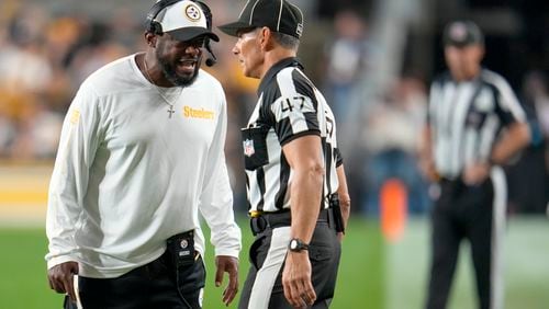 Pittsburgh Steelers head coach Mike Tomlin, left, talks to line judge Tim Podraza (47) during the first half of an NFL football game against the Dallas Cowboys, Sunday, Oct. 6, 2024, in Pittsburgh. (AP Photo/Gene J. Puskar)