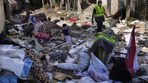 A Hezbollah paramedic walks between debris after an airstrike hit an apartment in a multistory building, in central Beirut, Lebanon, Thursday, Oct. 3, 2024. (AP Photo/Hussein Malla)