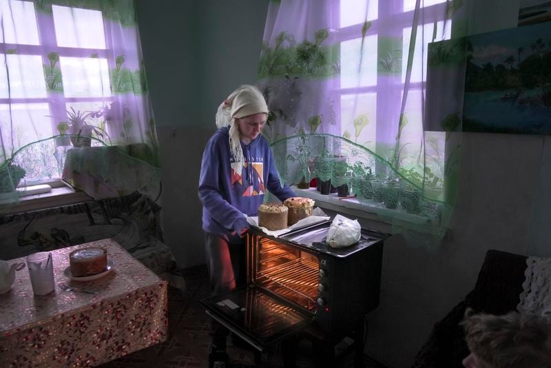 Daria Strukova takes Easter cakes off a stove in her family home in the remote mountain village of Orlovka, Georgia, Saturday, May 4, 2024. (AP Photo/Kostya Manenkov)