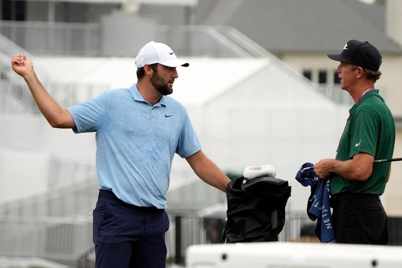 Scottie Scheffler, left, works on the driving range at the St. Jude Championship golf tournament Wednesday, Aug. 14, 2024, in Memphis, Tenn. The tournament is scheduled to begin Thursday. (AP Photo/Mark Humphrey)