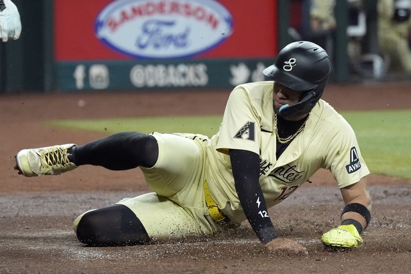 Arizona Diamondbacks' Lourdes Gurriel Jr. scores against the Los Angeles Dodgers during the first inning of a baseball game Friday, Aug. 30, 2024, in Phoenix. (AP Photo/Ross D. Franklin)