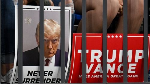 Supporters put down their signs during a rally at the Georgia State University’s convocation center on Saturday, August 3, 2024 in Atlanta. Former President Donald Trump and Vice-Presidential candidate JD Vance are holding their first rally together in Georgia on Saturday at the same place – the GSU Convocation Center- Kamala Harris held hers earlier this week.  (Hyosub Shin / AJC)