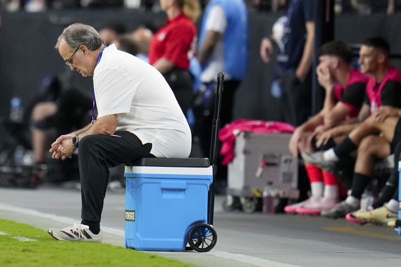 Uruguay's coach Marcelo Bielsa sits on a cooler during during a Copa America quarterfinal soccer match against Brazil in Las Vegas, Saturday, July 6, 2024. (AP Photo/Julio Cortez)