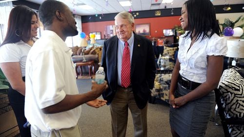 110406 Atlanta -- Aaron's founder Charlie Loudermilk (center) speaks with store employees (from left) Karla Patterson, Quamall Mays and Ashley Wilson at the Aaron's store on Buford Highway in Atlanta Wednesday, April 6, 2011.  Bita Honarvar bhonarvar@ajc.com