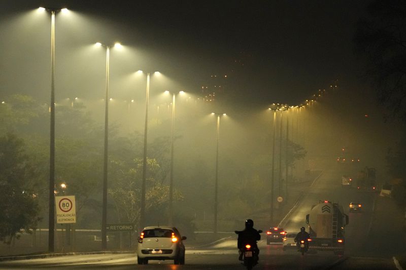 Smoke from a fire in the environmentally protected area of Brasilia National Park affects Brasilia, Brazil, before sunrise Monday, Sept. 16, 2024. The head of the agency that manages protected areas, Mauro Pires, told the local press that the fire is man-made and appears to have started near the edge of a farm. (AP Photo/Eraldo Peres)