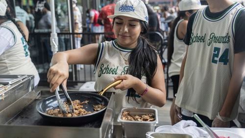 Students from Food and Finance high school make taco dough during a summer block party outside the Barclays Center, Thursday, July. 11, 2024, in New York. (AP Photo/Jeenah Moon)