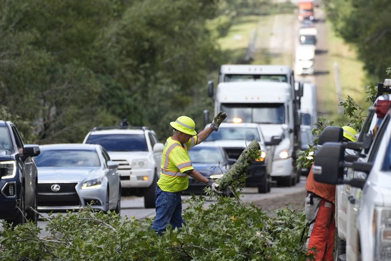 Workers with the Georgia Department of Transportation clear debris from Interstate 20 in the aftermath of Hurrican Helene Friday, Sept. 27, 2024, in Grovetown, Ga. (AP Photo/John Bazemore)