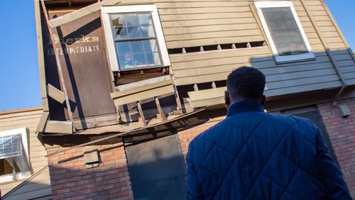 Atlanta Mayor Andre Dickens stares back at a child looking out of a broken window as he reviews the conditions at Forest Cove Apartments in the Thomasville Heights community on Saturday, Feb. 12, 2022. (City of Atlanta)