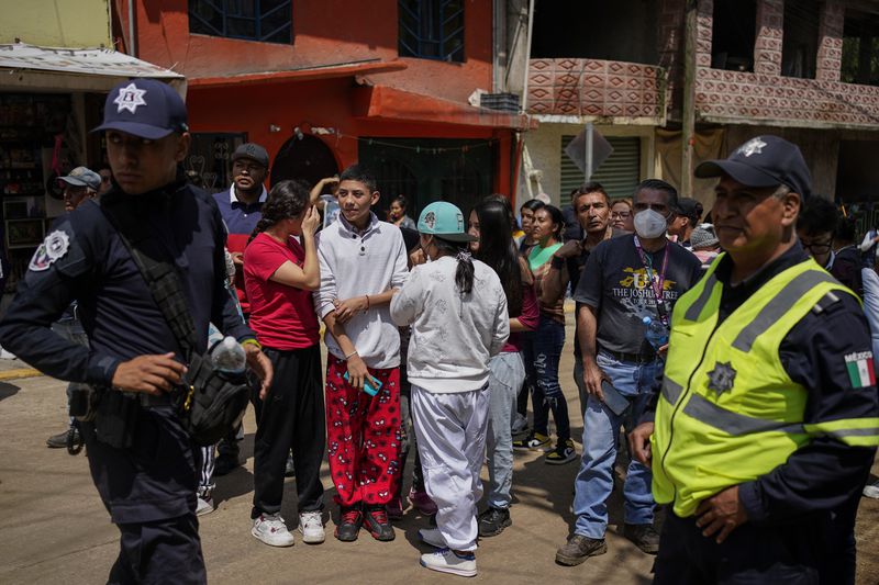 Residents gather near the site where various were buried after a landslide caused by rains, in Naucalpan, Mexico, Tuesday, Sept. 17, 2024. (AP Photo/Felix Marquez)