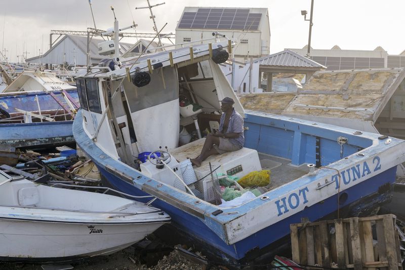 Fisherman Hamilton Cosmos looks at vessels damaged by Hurricane Beryl at the Bridgetown Fisheries in Barbados, Monday, July 1, 2024. (AP Photo/Ricardo Mazalan)
