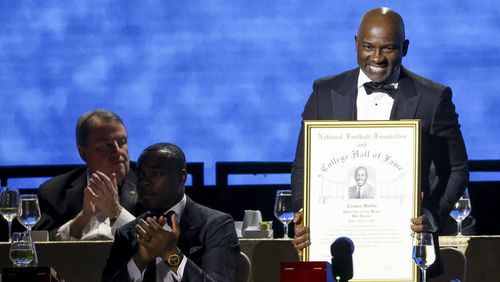 Former New Mexico wide receiver Terance Mathis holds up his College Football Hall of Fame Award during the National Football Foundation Awards Dinner, Tuesday, Dec. 5, 2023, in Las Vegas. (AP Photo/Ian Maule)